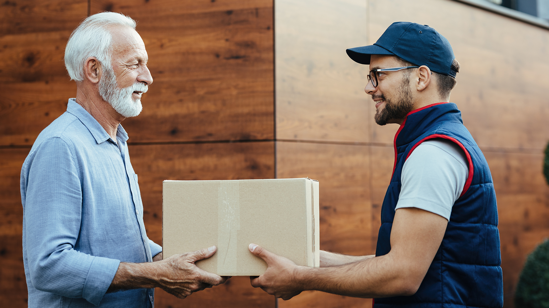 Courier handing a parcel to a customer at their door